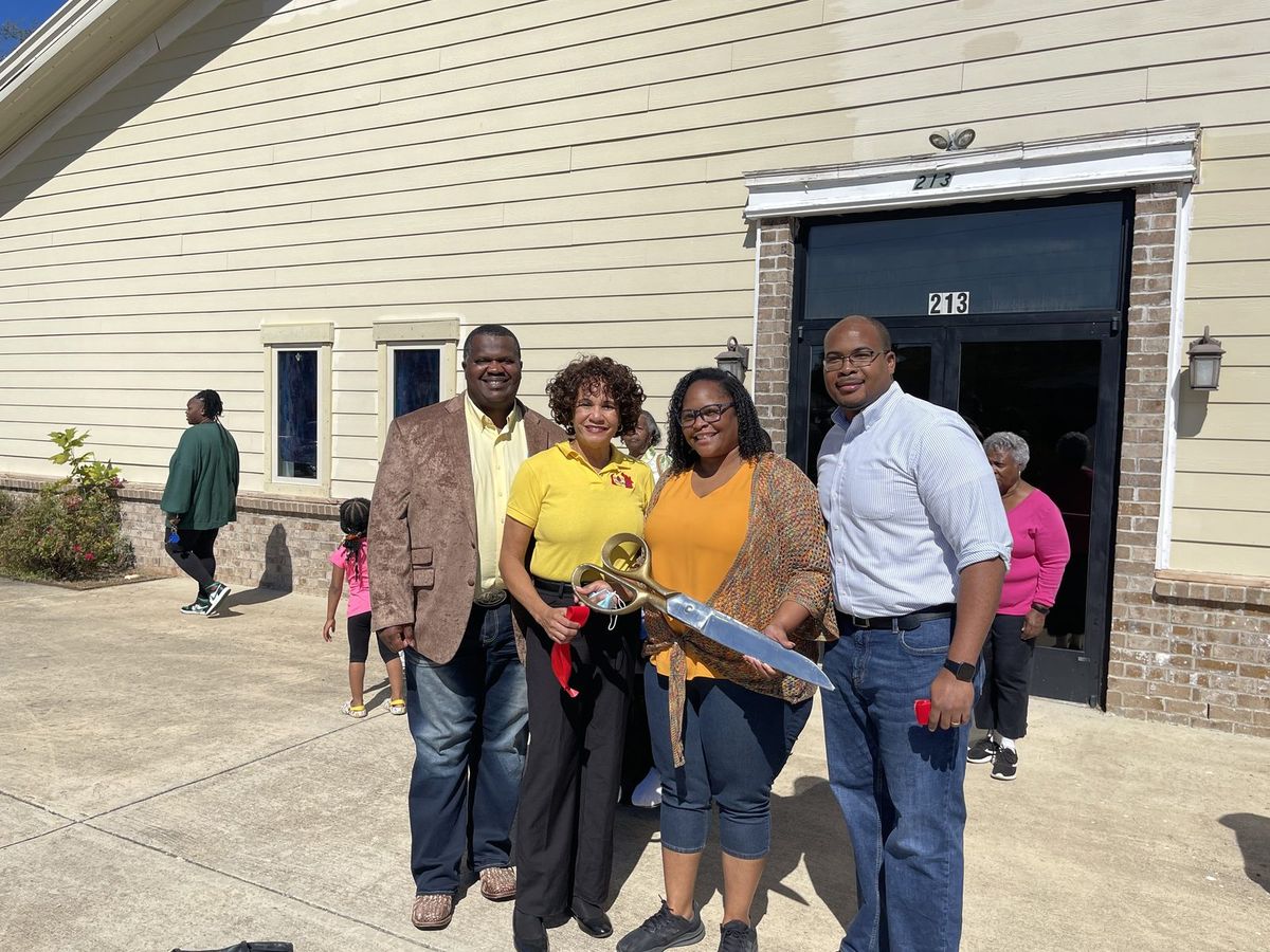 Four smiling members of Flint River Church outside the front doors at 213 Winchester Road